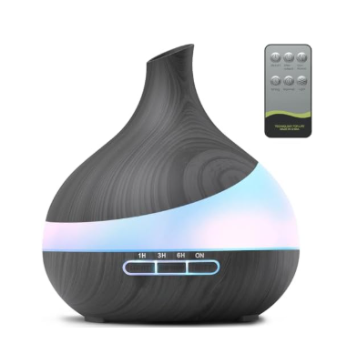 Dark wood grain teardrop-shaped essential oil diffuser featuring a central LED light strip, timer buttons (1H, 3H, 6H), and an accompanying gray remote control.