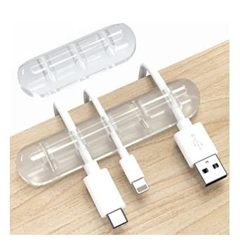 Clear transparent cable organizer clips with multiple slots holding white USB charging cables on wooden desk surface with detached clip shown above