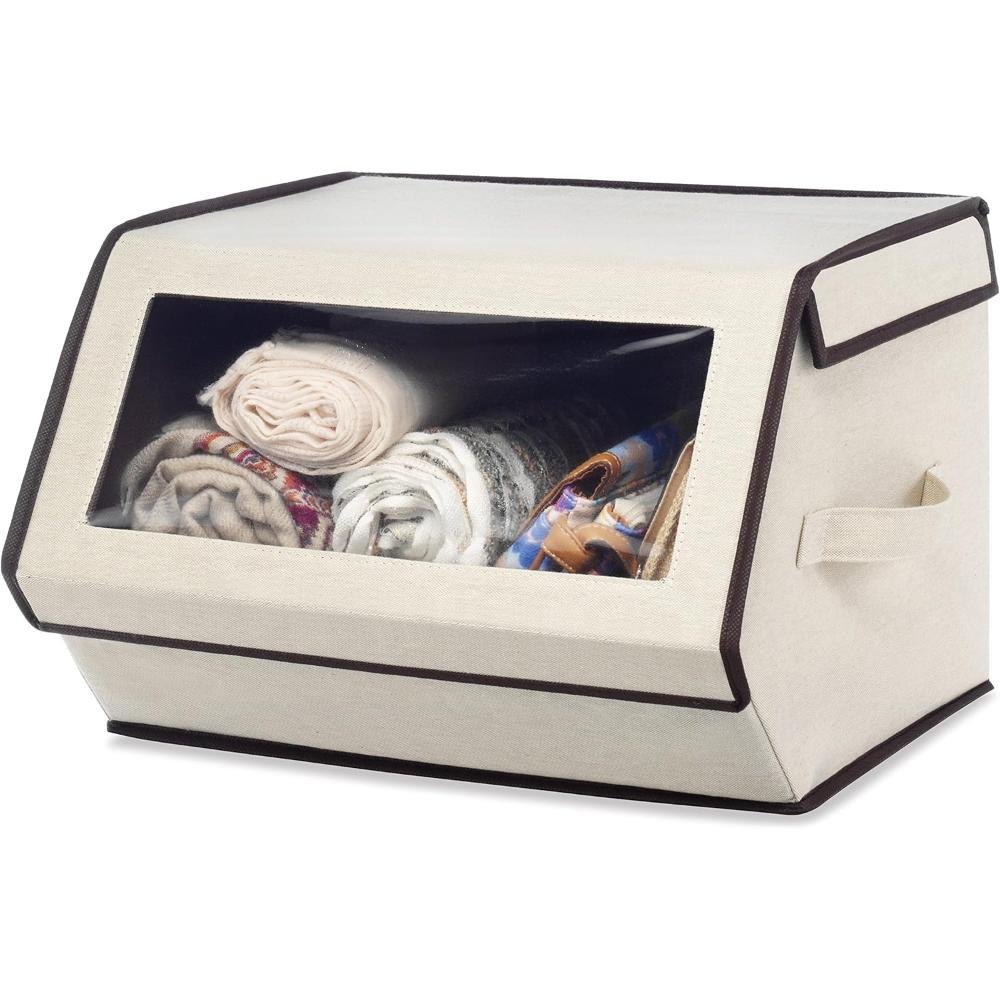 Beige fabric storage box with clear window top showing folded linens, blankets, and scarves with reinforced handles