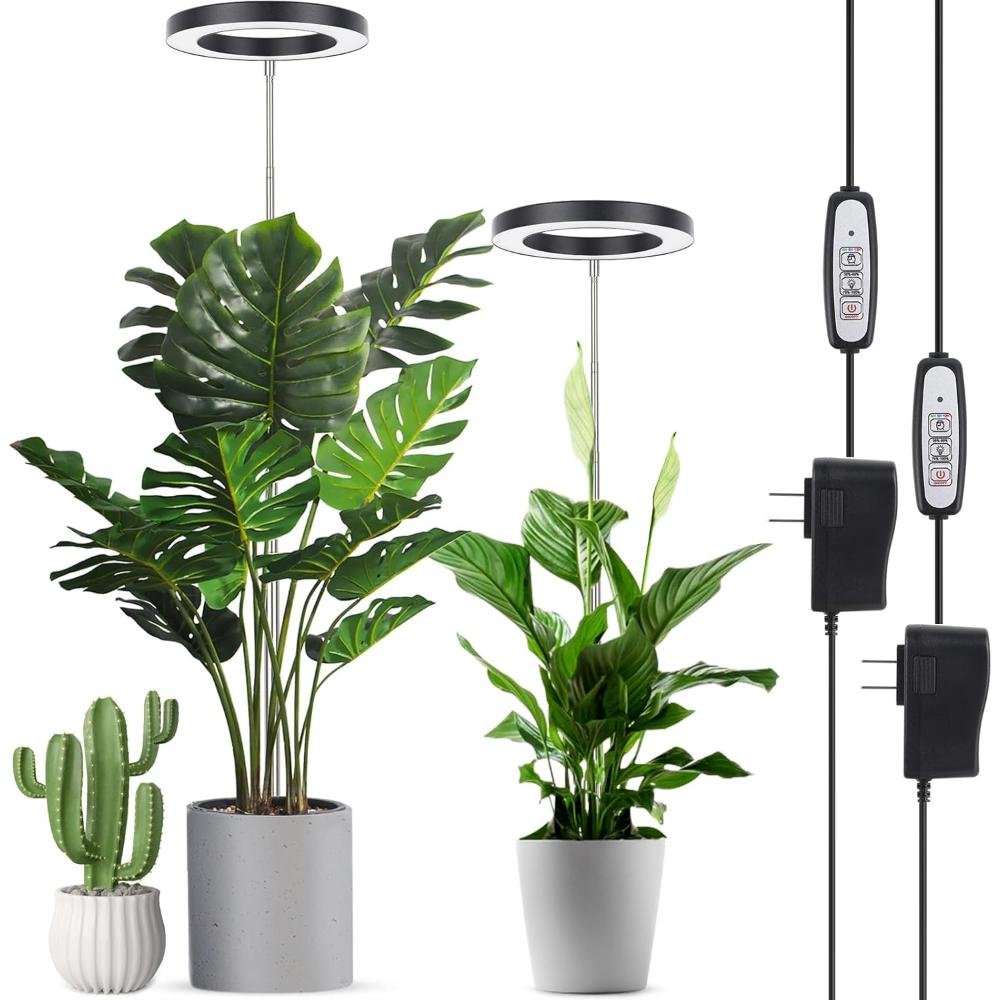 Two circular LED ring grow lights on adjustable height poles illuminating monstera and peace lily plants with inline timer controls and power adapters