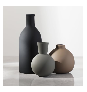 Set of three modern matte ceramic vases in black, grey, and brown earth tones arranged on a surface.