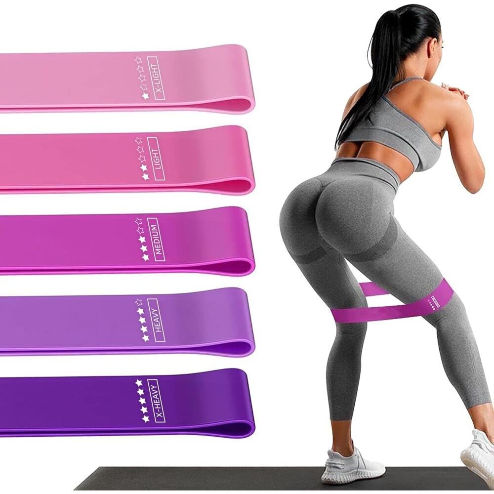 Set of five resistance loop bands in graduated pink and purple shades with woman demonstrating glute exercise on yoga mat