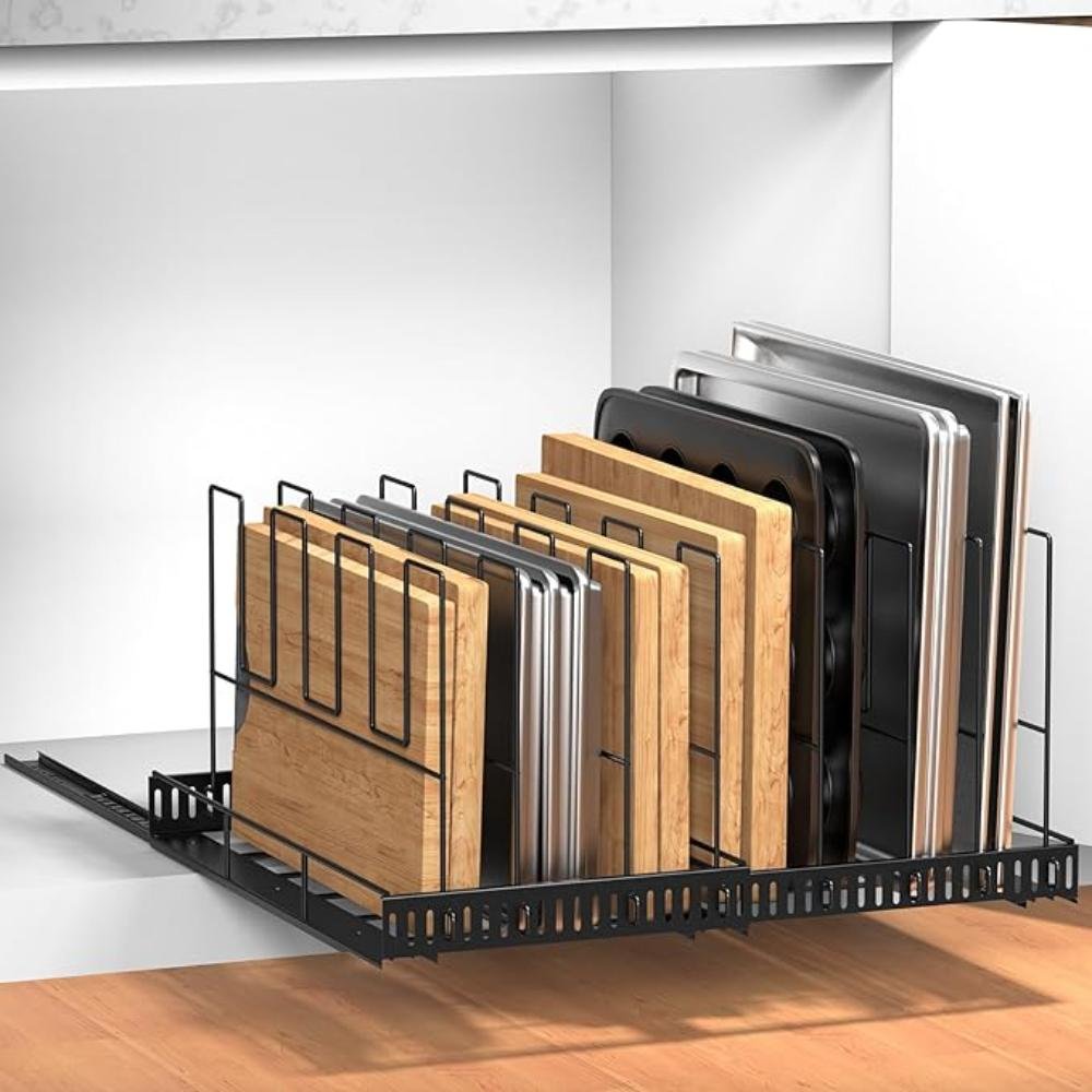 Black sliding pull-out cabinet organizer with vertical dividers holding cutting boards, baking sheets, and pan lids