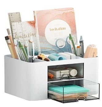 White multi-compartment desk organizer with clear acrylic drawer holding stationery, invitations, pens, rulers, and office supplies in organized sections